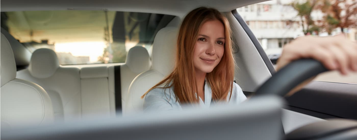 A woman is shown driving a vehicle to a dealership to sell her car.