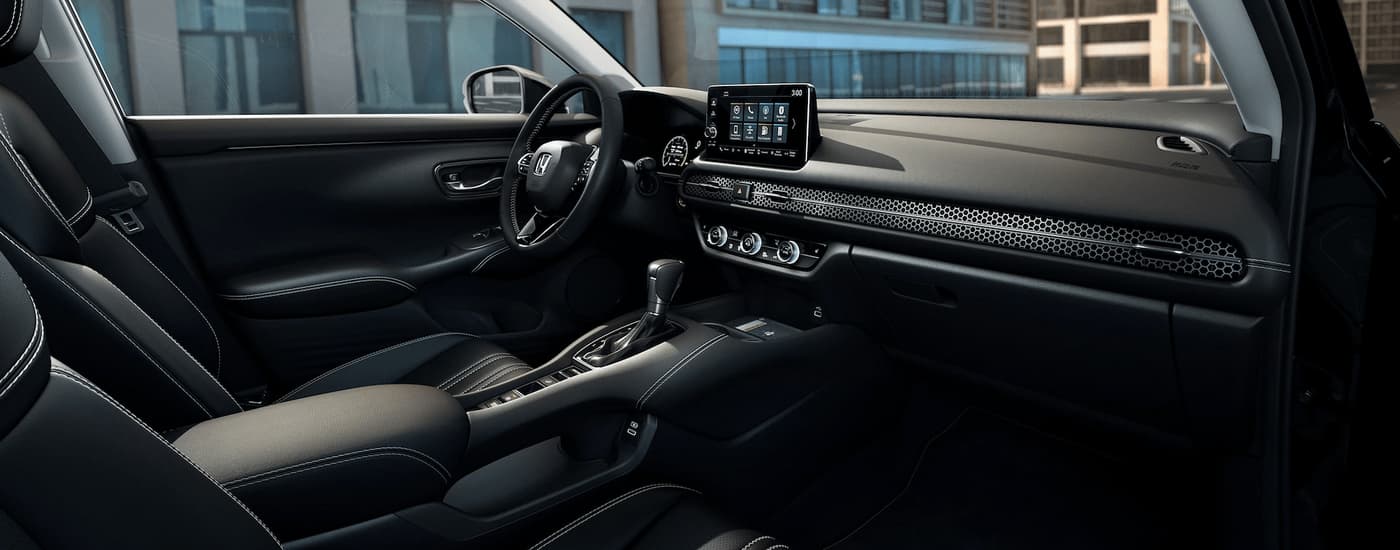 The black interior of a 2023 Honda HR-V shows the center console and dashboard.