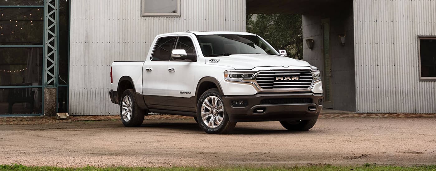 A white 2020 Ram 1500 Longhorn is shown parked by a barn after leaving a used truck dealer.