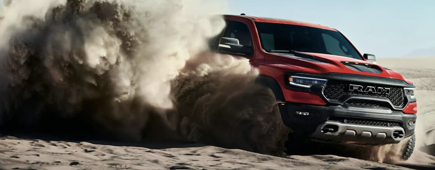 A red 2021 Ram TRX is shown off-roading in a desert.