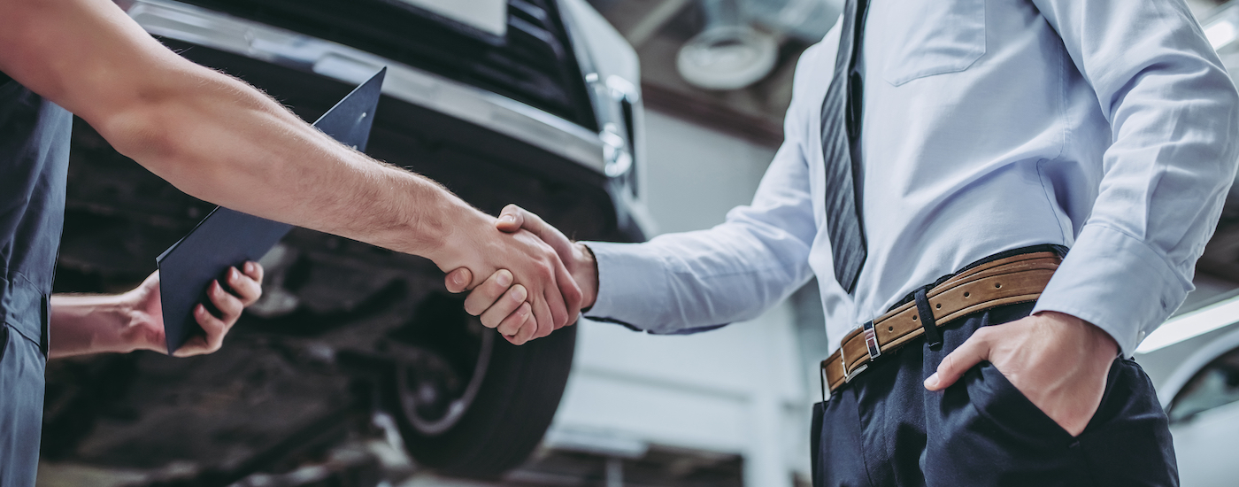 A person is shown shaking hands after searching "sell my car."