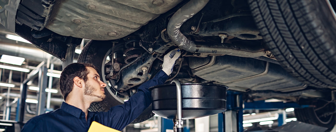 A mechanic is shown doing maintenance on a vehicle.