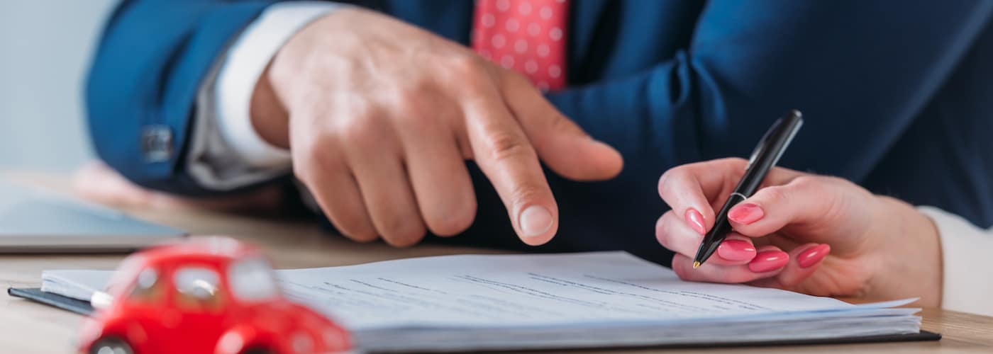 Man Pointing at Document Woman Signing