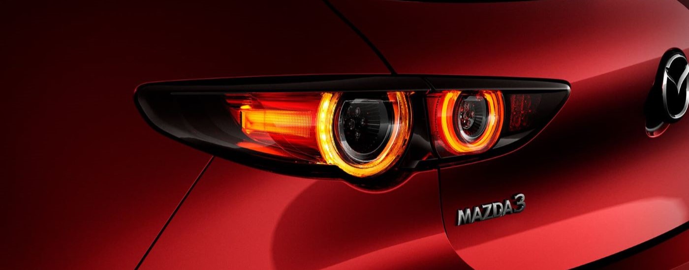 A close up shows the driver side taillight on a red 2022 Mazda3.