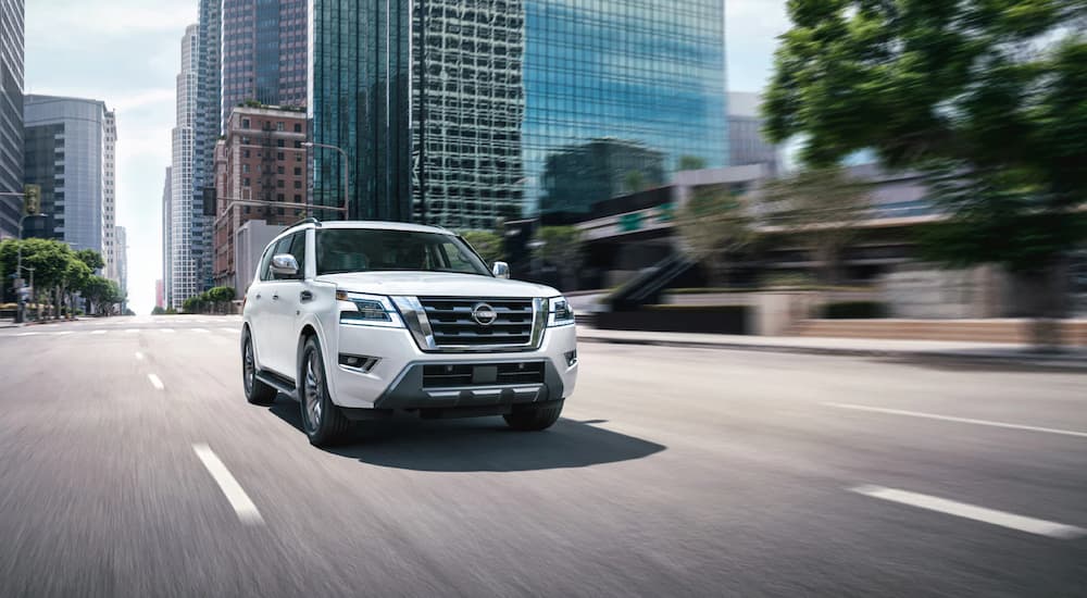 A white 2022 Nissan Armada is shown driving on a city street after leaving a Rockford, IL Nissan dealer.