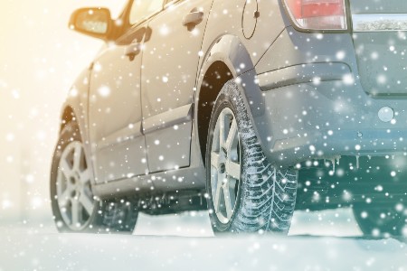 Close up of a gray car driving in snow