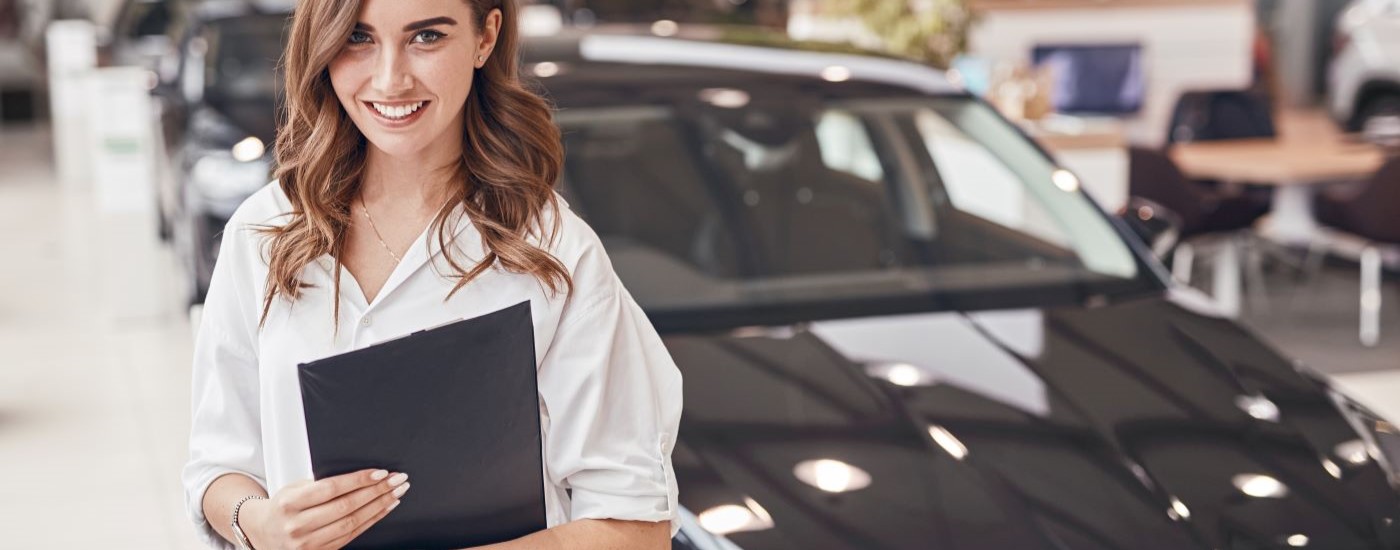 A salesperson is smiling in a showroom.