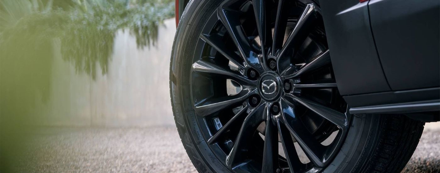 A close up shows the black wheel on a red 2022 Mazda CX-30.