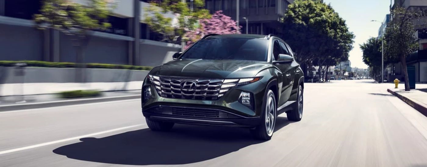 A grey 2023 Hyundai Tucson Hybrid Limited is shown on a city street.