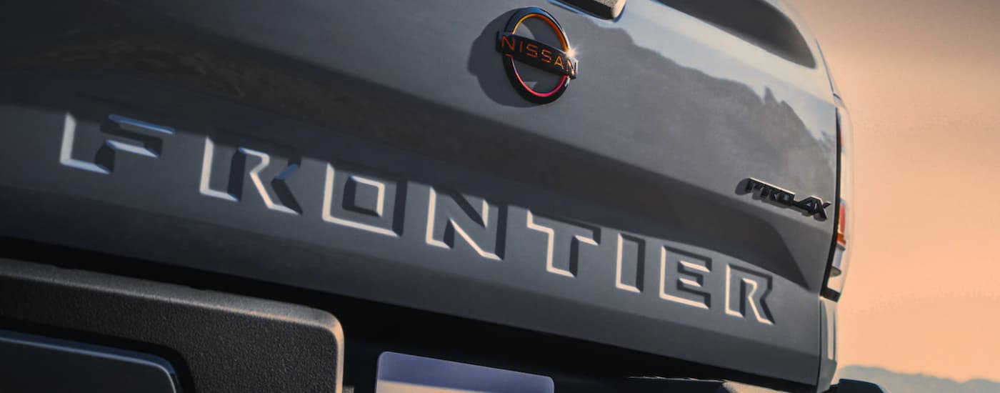 A grey 2023 Nissan Frontier is shown from the rear.
