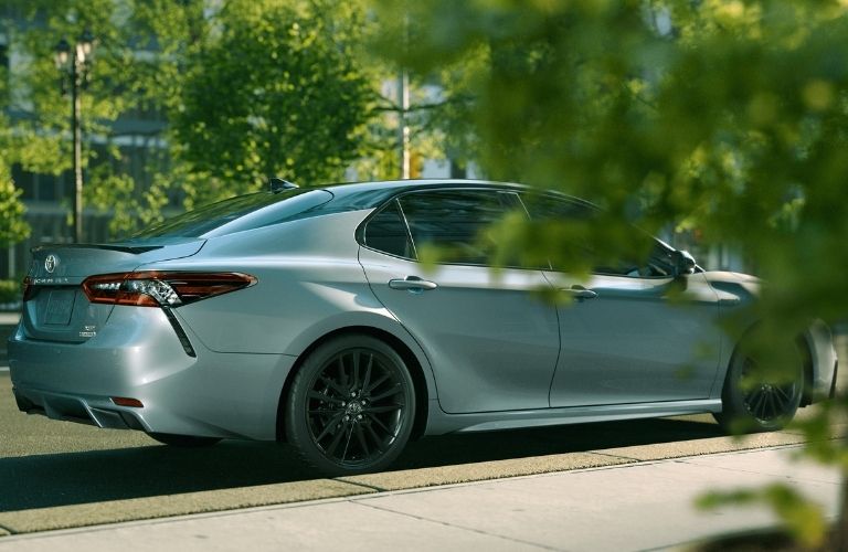 2021 Toyota Camry Hybrid behind trees