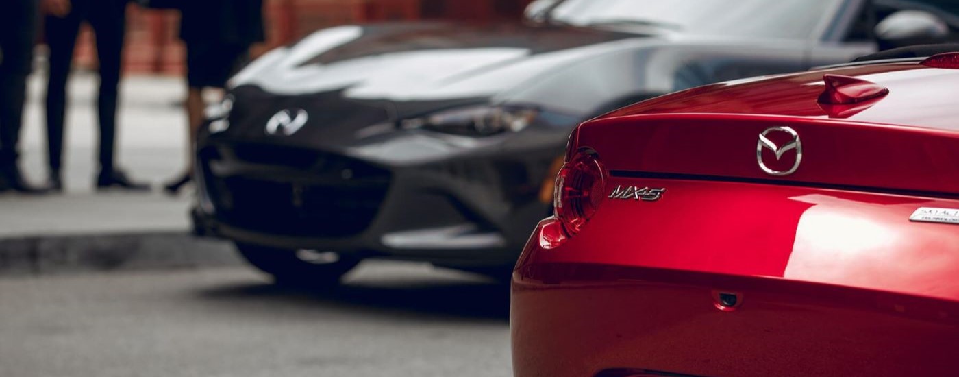 A grey and a red 2019 Mazda MX-5 Miata are shown parked after visiting a Edmonds Mazda dealer.