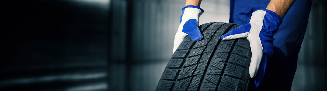 A mechanic rolling a tire