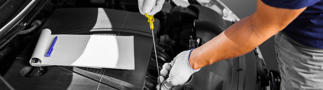 A mechanic working on a vehicle for an oil change