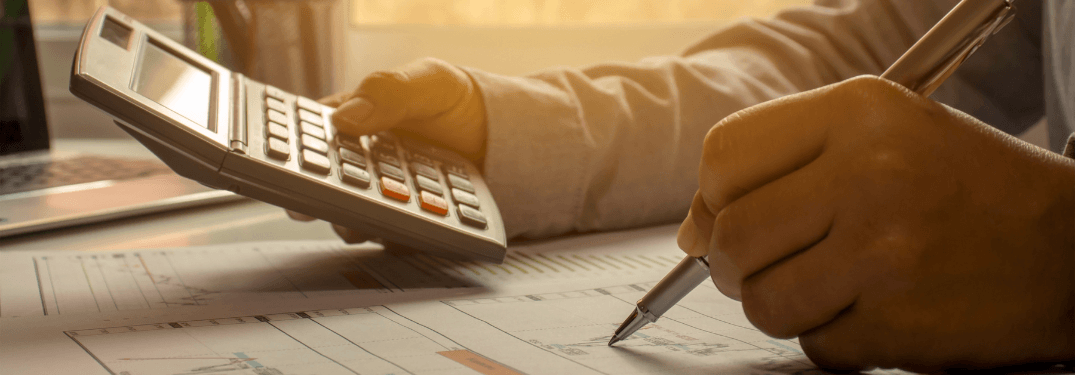 A man using a calculator and pen