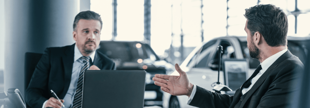 Two men talking about interest rates at a desk