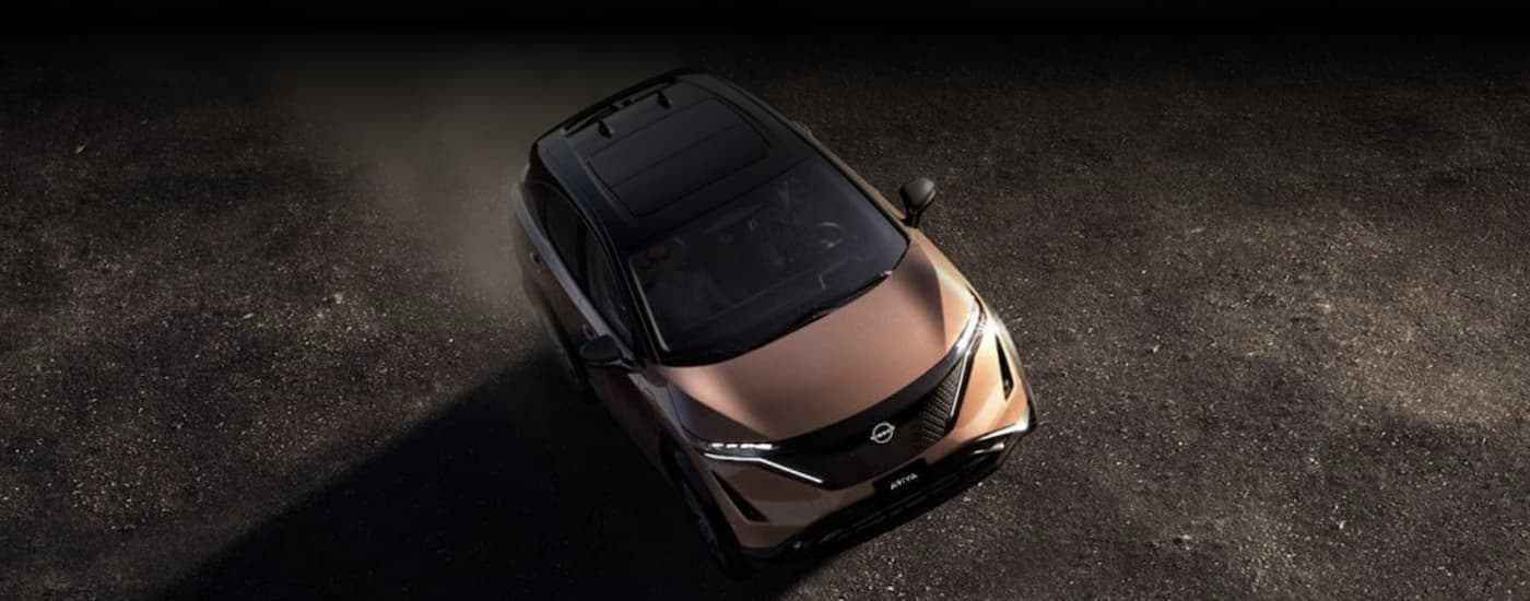 A gold 2023 Nissan Ariya is shown off-roading.