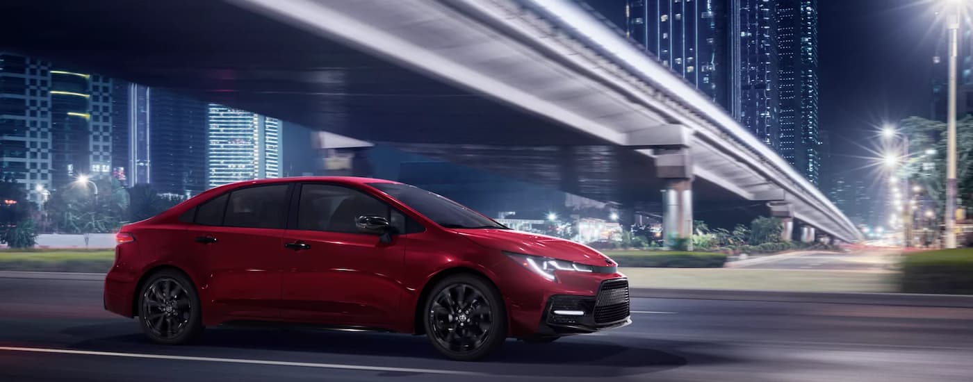 A red 2022 Toyota Corolla SE Nightshade is shown from the side driving on a highway.