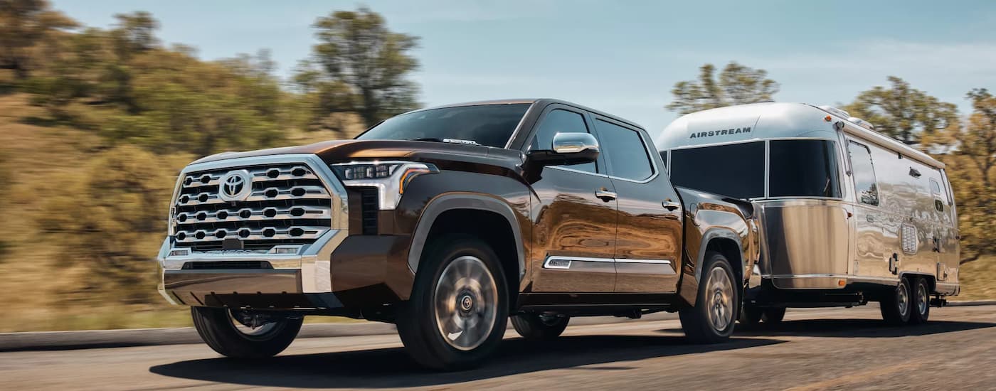 A dark brown 2022 Toyota Tundra is shown towing a silver Airstream trailer.