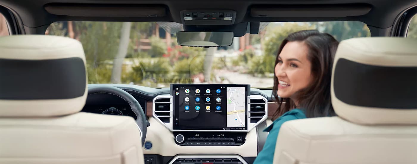 A woman is shown sitting in the passenger side seat of a 2022 Toyota Tundra.
