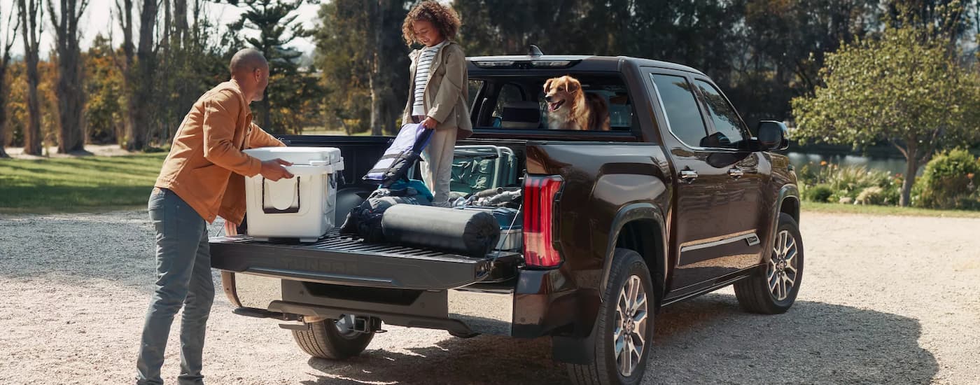 A family is shown taking cargo out of the bed of a 2022 Toyota Tundra.