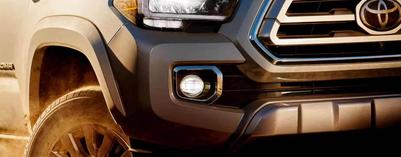A close-up of the passenger-side headlight of a silver 2023 Toyota Tacoma.