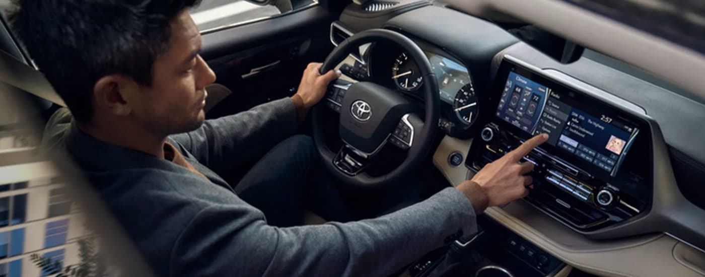 A person is shown driving a 2022 Toyota Highlander Platinum.