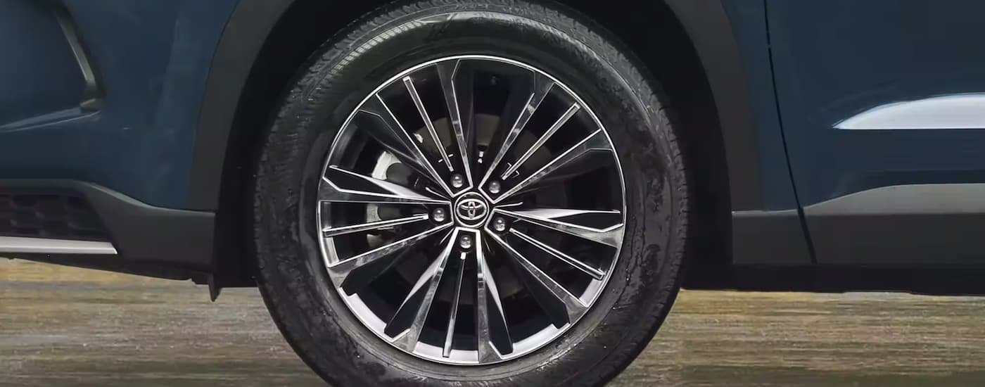 A close up of the wheel of a blue 2024 Toyota Grand Highlander is shown at a Toyota Dealer near Sacramento, CA.