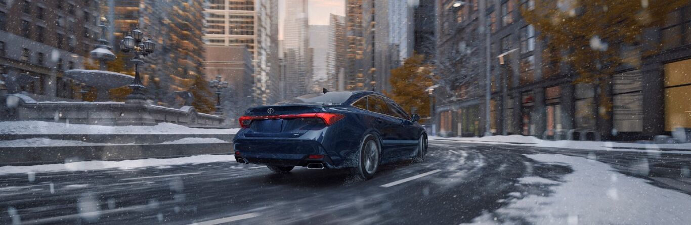 2021 Toyota Avalon AWD blue exterior rear fascia driving in roundabout in city