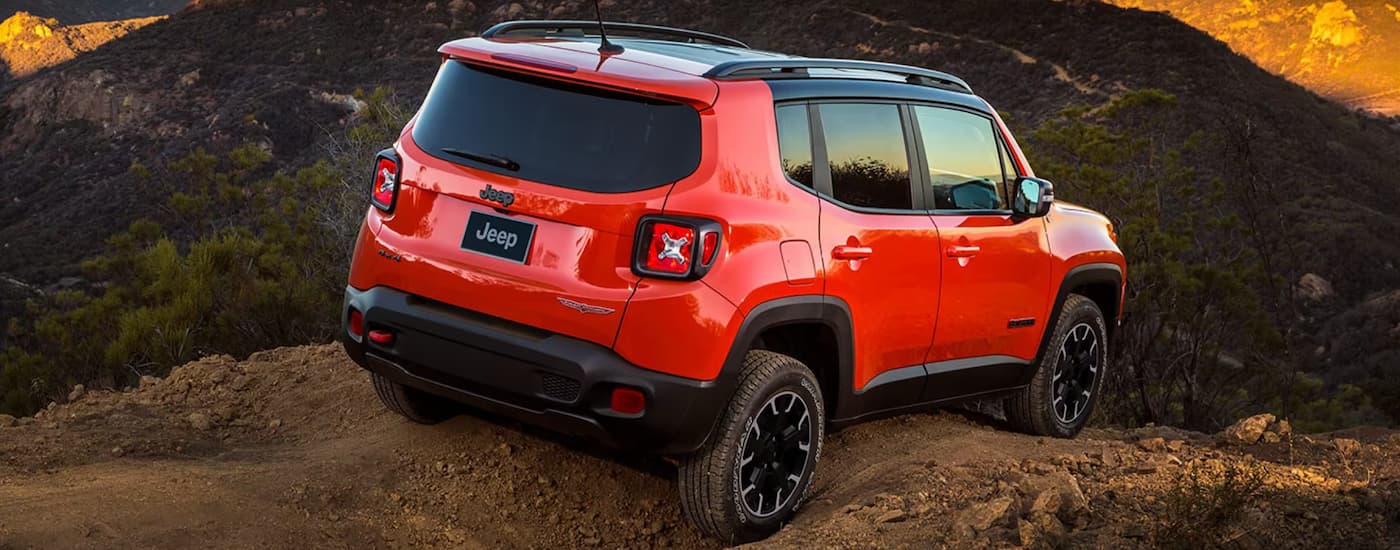 A red 2023 Jeep Renegade is shown from the side parked in the mountains after leaving a Jeep dealer near Leduc.