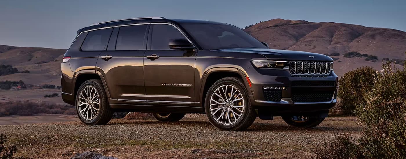 A dark grey Jeep Grand Cherokee is shown from the side.