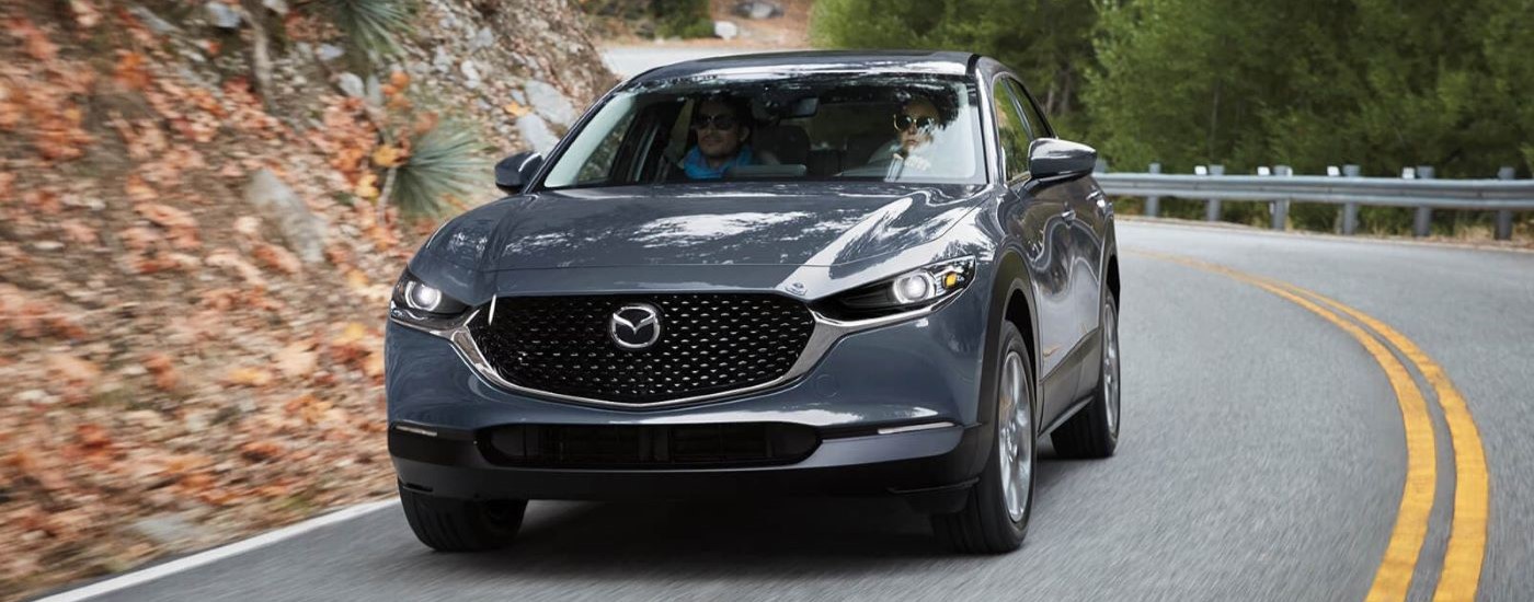 A grey 2023 Mazda CX-30 is shown rounding a corner after visiting a Mountlake Terrace Mazda dealer.