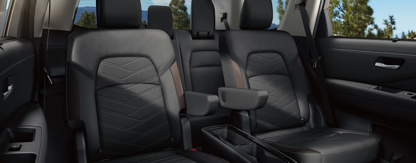 The black interior of a 2023 Nissan Pathfinder shows the rear seating.