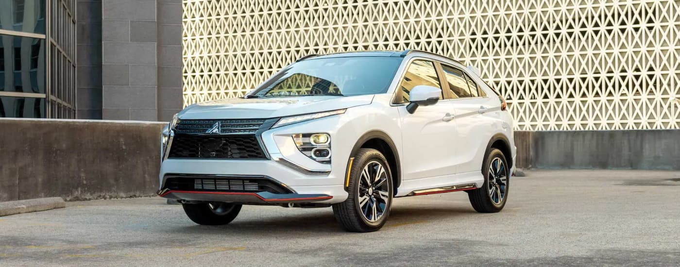 A white 2023 Mitsubishi Eclipse Cross is shown from the front parked in a lot.