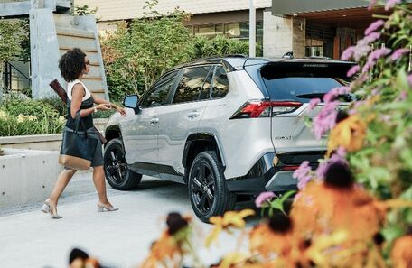 2021 Toyota RAV4 white with black roof parked behind flower