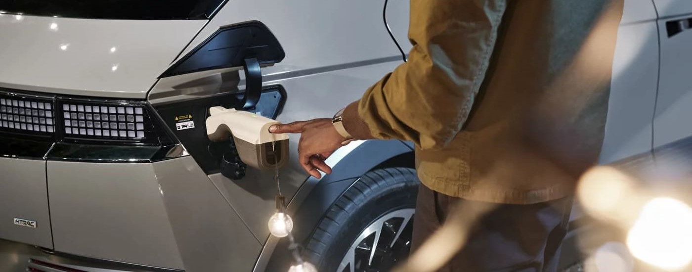 A person is shown charging a silver 2023 Hyundai Ioniq 5.