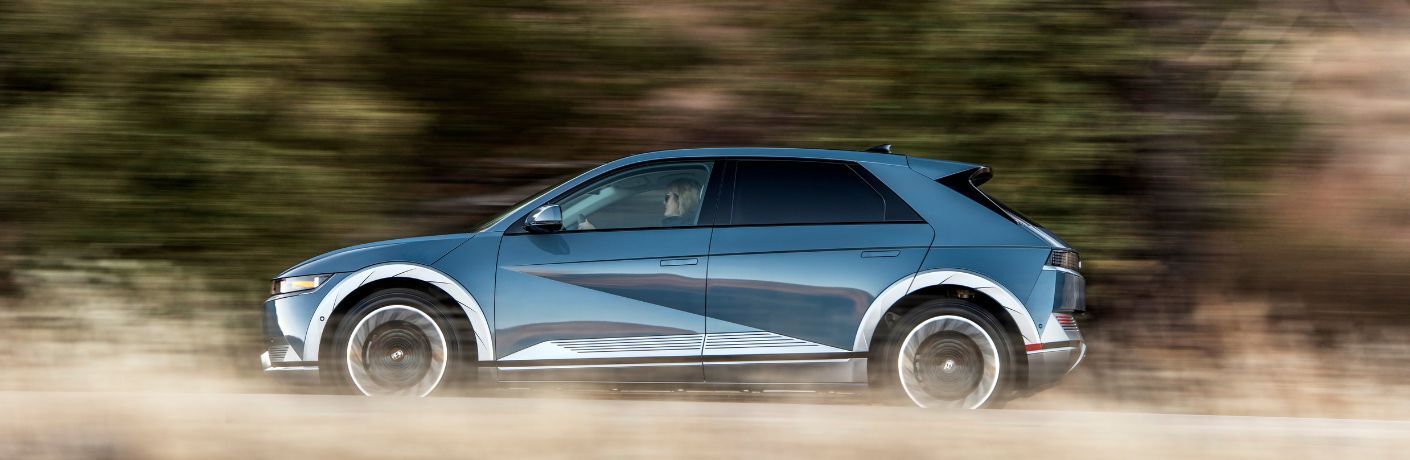 Side profile of a blue 2023 Hyundai IONIQ 5 on the move.