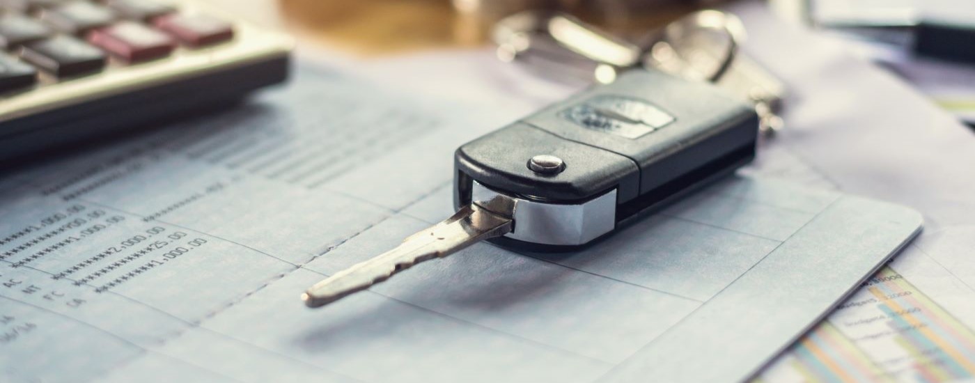 A close up shows a keyfob on a desk.