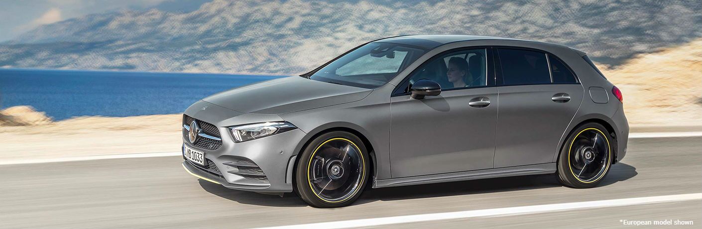 A 2020 Mercedes-Benz A-Class drives along a desert highway beside an azure lake. 