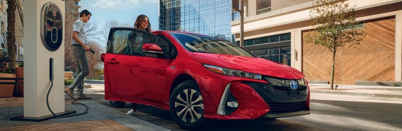 Man and woman charge a 2021 Toyota Prius Prime