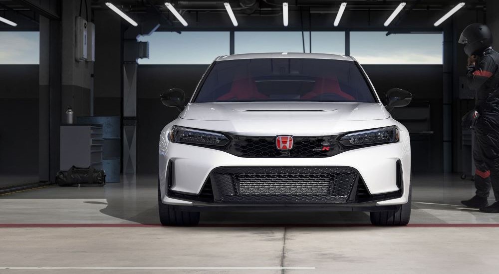 A white 2023 Honda Civic Type R is shown from the front parked in a garage.