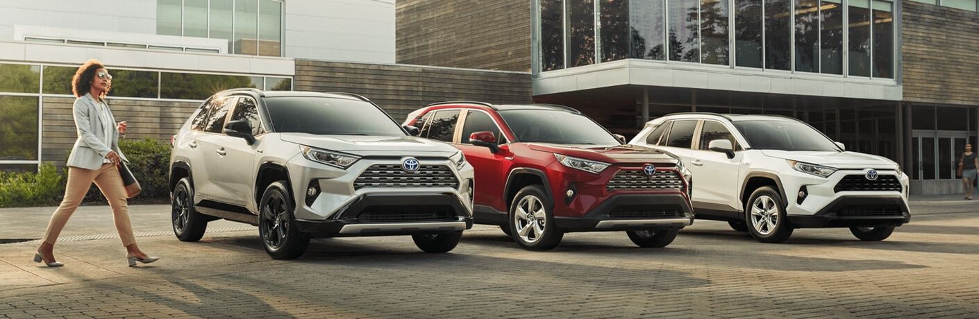 Woman struts out confidently in front of various 2021 Toyota RAV4 models