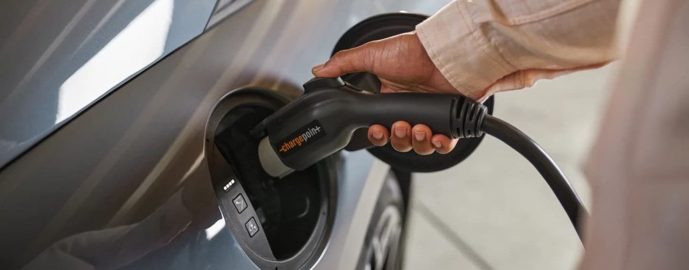 A person is shown plugging a charger into a grey 2023 Hyundai IONIQ 6.