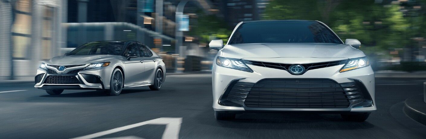 Two 2021 Toyota Camry models ride on a road
