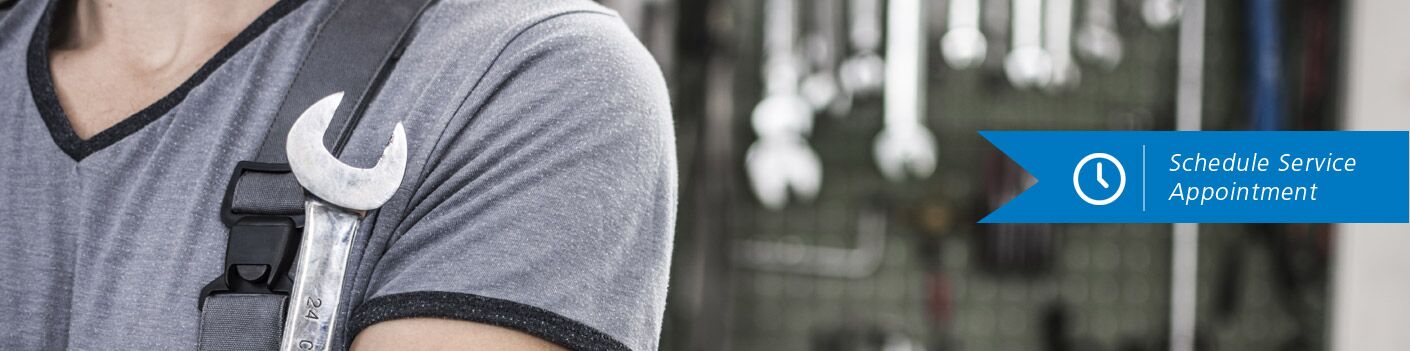 Man holds a wrench against his armpit. Text on a little banner reads, "Schedule Service Appointment"