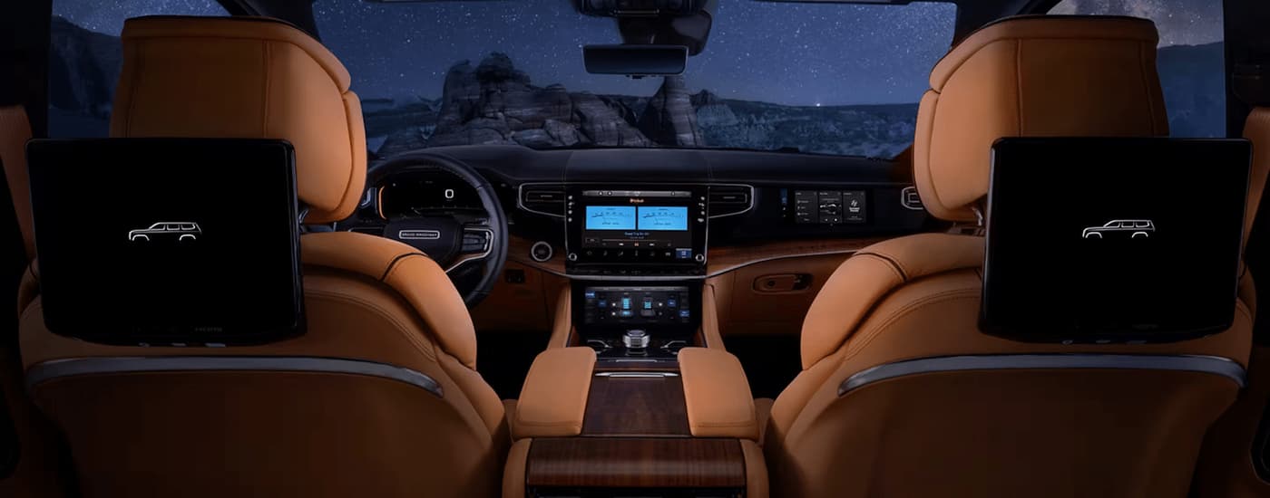 The brown leather interior of a 2023 Grand Wagoneer shows the front seating and center console.