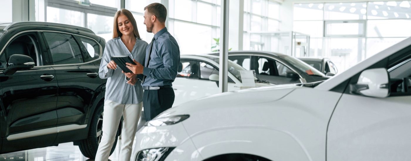 A customer and salesperson are discussing bad credit car loans at a dealership.