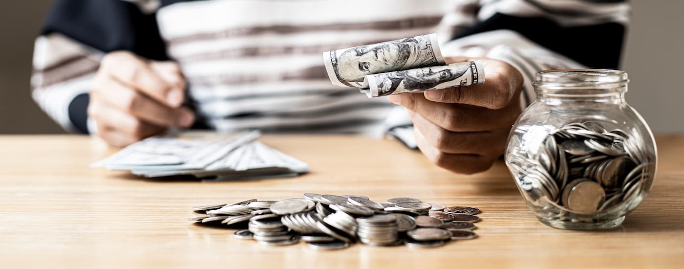 A close up shows a person counting money.