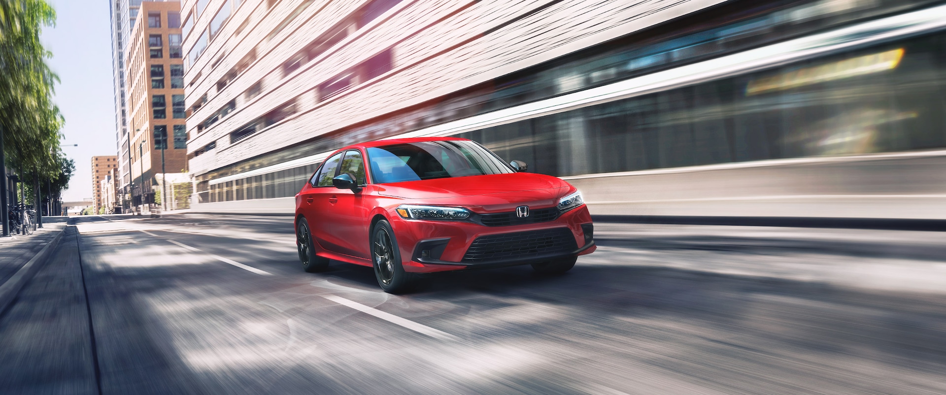 A red 2023 Honda Civic Touring for sale is shown driving on a city street.