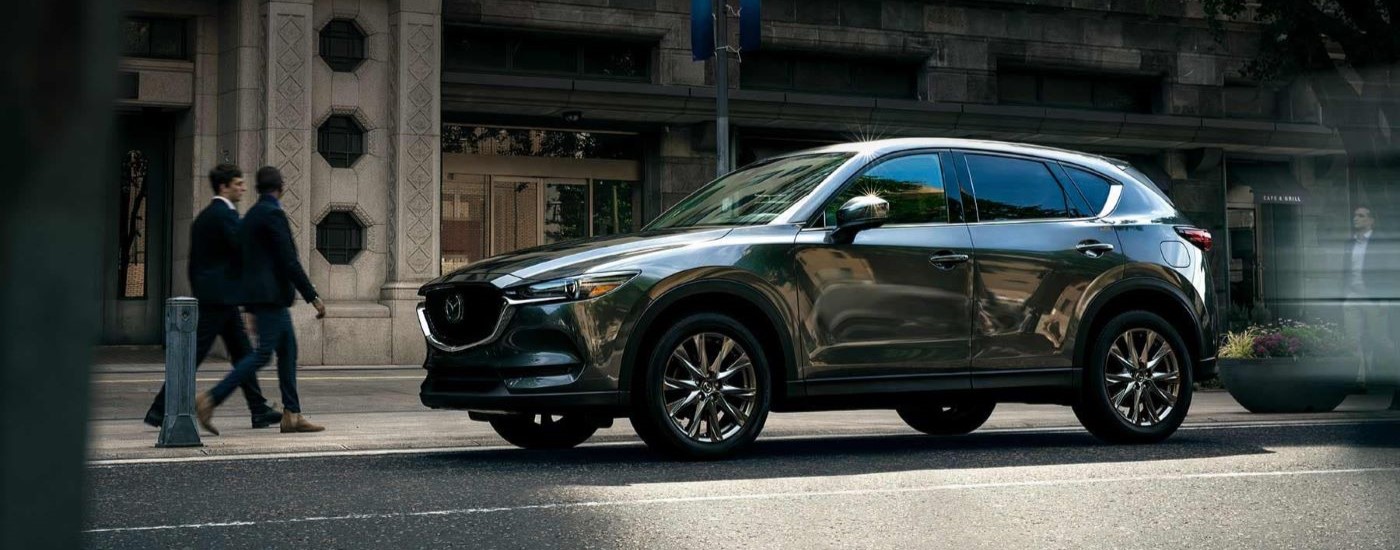 A dark grey 2021 Mazda CX-5 is shown parked on a city street.